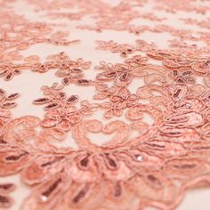 an image of a table cloth that is pink and gold color with flowers on it