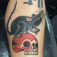 a tattoo with a rat on top of a skull