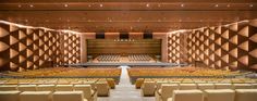 an empty auditorium with rows of seats in front of the stage and wall dividers