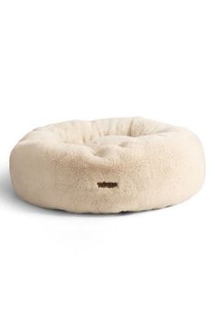 a dog bed that is made out of sheepskin and has a small hole in the middle