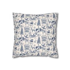 a blue and white pillow with an image of trees, deers and snowflakes