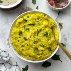 a bowl filled with mashed potatoes and garnished with cilantro