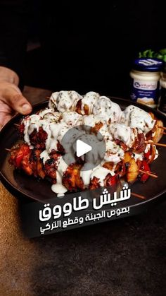 a person holding a plate with food on it and the caption in arabic above it