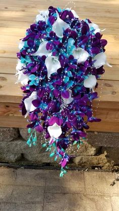 a purple and white bouquet hanging from a wooden bench