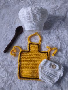 a crocheted hat, apron and pot holder are laying on a white surface