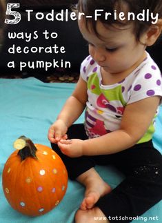 a toddler sitting on the floor playing with a pumpkin that says 5 toddler - friendly ways to decorate a pumpkin