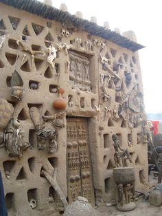 an adobe building with carvings on the front and side walls that are covered in clay