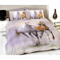 two horses running in the grass on a bed with matching comforter and pillow cases