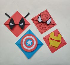 four different types of origami are displayed on a white surface, including one with a mask and the other with an iron man's face