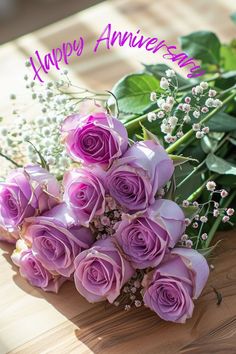 a bouquet of purple roses sitting on top of a wooden table with the words happy anniversary