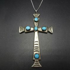 "VINTAGE NAVAJO CROSS PENDANT DESCRIPTION: This impressive pendant is casst and hand-stamped the adorned with 5 lovely specimens of bright blue turquoise. An 18\" sterling silver box chain is included. This pendant will be a lovely addition to your collection of fine vintage Native American jewelry. MEASUREMENTS: Pendant measures 3 1/2\" x 2\" Chain measures 18\" WEIGHT: Pendant weighs 18.8 grams Chain weighs 1.6 grams Total weight: 20.4 grams SIGNED: R (Navajo) STERLING: yes, stamped sterling" Bohemian Blue Cross Pendant Necklace, Blue Bohemian Necklace With Cross Pendant, Vintage Turquoise Jewelry With Oxidized Finish, Vintage Turquoise Necklace With Oxidized Finish As Gift, Vintage Turquoise Jewelry With Large Pendant, Antique Nickel-free Cross Pendant Jewelry, Blue Oxidized Sterling Silver Jewelry, Blue Oxidized Pendant Jewelry, Blue Sterling Silver Jewelry With Oxidized Finish