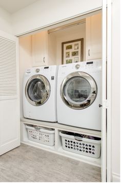 a washer and dryer in a white laundry room with open closet doors to the side