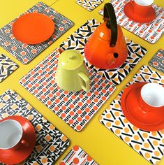 orange and white placemats with tea pots on them