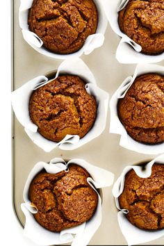 twelve muffins in white paper lined up on a tray with napkins around them