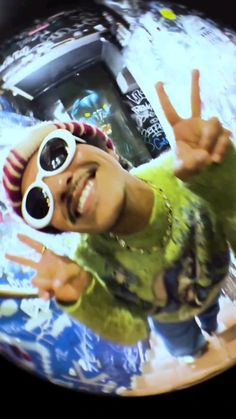 a young man wearing sunglasses making the peace sign