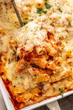 a white casserole dish filled with chicken parmesan sauce and melted cheese