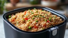 a black container filled with rice and vegetables