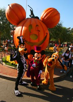 mickey mouse and friends in front of a pumpkin at the disneyland world halloween parade on oct 29, 2012