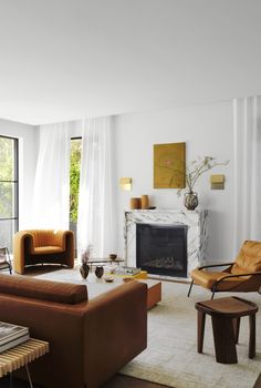 a living room filled with furniture and a fire place in front of a large window