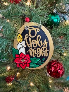 a christmas ornament hanging on a tree with ornaments around it and the words merry night