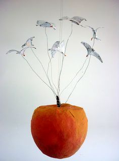 an orange with birds flying out of it