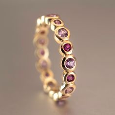 Special shades of natural pink sapphires add a beautiful color splash to this eternity band which is also stackable. This ring is ready to ship in 14K yellow gold, size 7.5 and can be ordered in all other sizes and gold tones upon request. Metal: 14K yellow gold Size: 7.5 Width: 4mm Height: ~2mm Stones: 9x2.5mm light pink natural sapphire, 9x2mm hot pink natural sapphire Stackable Pink Sapphire Ring For Wedding, Pink Round Cut Stackable Eternity Band, Pink Sapphire Stackable Ring For Anniversary, Pink Stackable Rings In Fine Jewelry Style, Pink Stackable Eternity Band For Anniversary, Pink Sapphire Stackable Rings With Round Band, Pink Ruby Stackable Jewelry, Pink Sapphire Stackable Promise Rings, Pink Stackable Half Eternity Rings