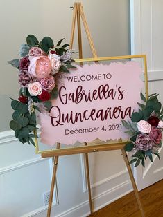 a welcome sign with flowers on it in front of a door that says gabiea's quinceauera