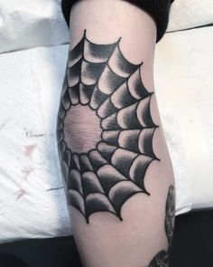 a spider web tattoo on the leg