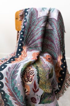 a multicolored blanket on a wooden chair