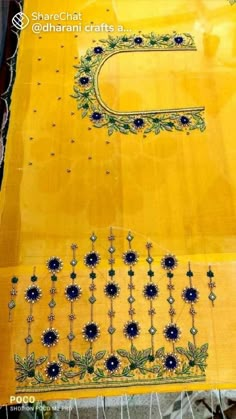 an embroidered yellow cloth with blue flowers on it