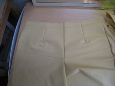 a pair of beige pants sitting on top of a bed