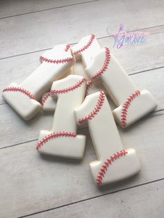 baseball themed cookies are arranged on a wooden table with white paint and red stringing