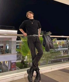 a man standing on top of a balcony next to a building