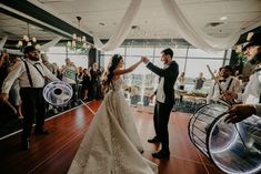 a bride and groom dancing on the dance floor at their wedding reception in front of an audience