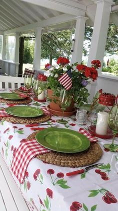 a table set with plates and flowers on it