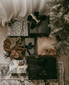 presents are laid out on the floor next to a christmas tree