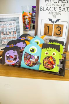 halloween treat bags in the shape of monster faces on a table with other items behind them