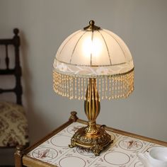 a table with a lamp on top of it and a tea cup next to it