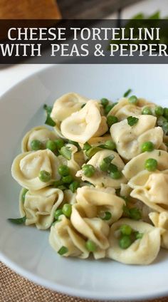 a white plate topped with pasta and peas