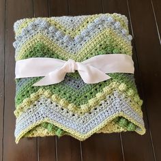 a crocheted blanket with a bow on it