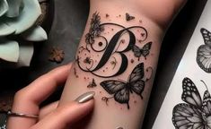 a woman's arm with butterflies and the letter b on it