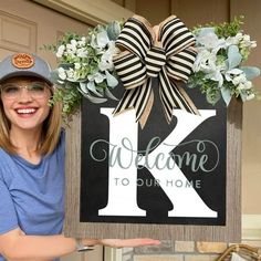 a woman holding up a sign that says welcome to our home