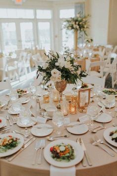 the table is set with white plates and silverware