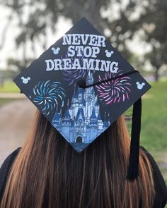 a graduation cap that says never stop dreaming with fireworks in the sky and castle on it