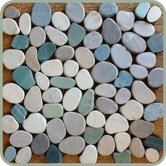 a bunch of rocks that are sitting on top of a wooden table and some sort of tile