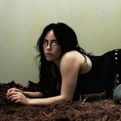 a woman with glasses laying on the ground