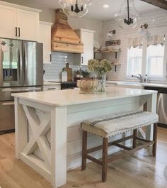 a kitchen with an island and stools in the center, surrounded by white cabinets