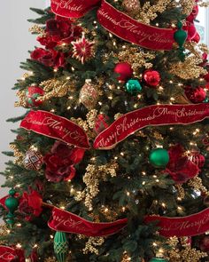 a christmas tree decorated with red and green ornaments, gold trimmings and ribbons