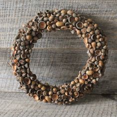 a close up of a wreath made out of shells on a wooden surface with other items in the background