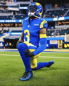 a football player sitting on the field in blue and yellow